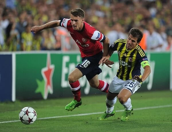 Arsenal's Aaron Ramsey Outmaneuvers Fenerbahce's Emre Belozoglu in UEFA Champions League Play-offs Clash