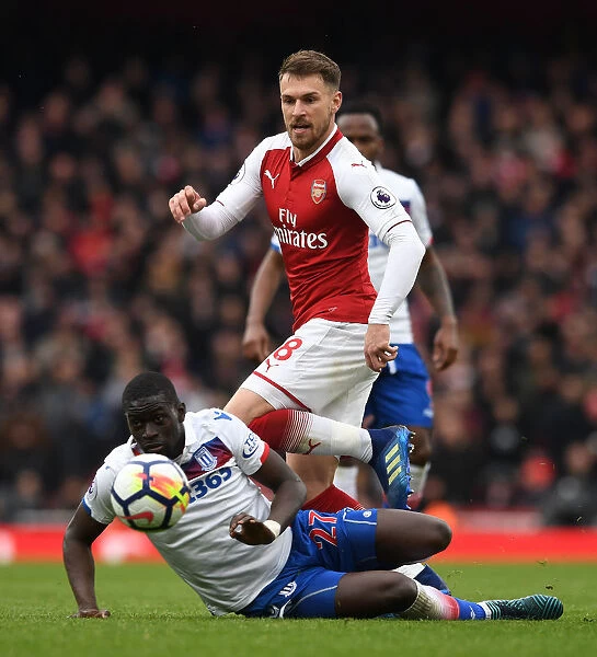 Arsenal's Aaron Ramsey Outmaneuvers Stoke's Badou Ndiaye during the Premier League Match