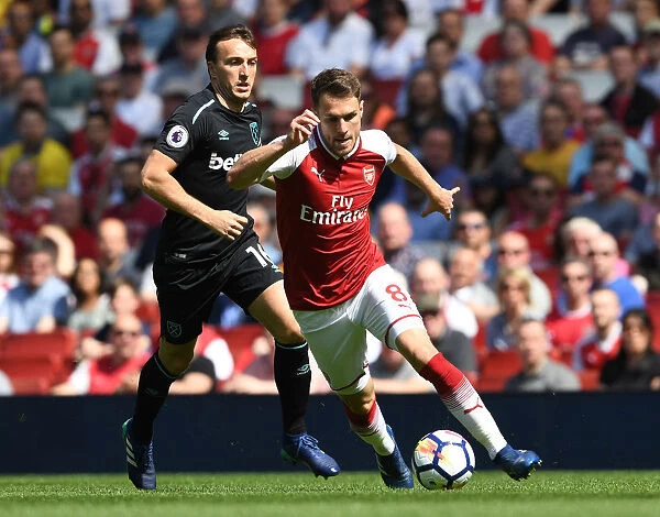 Arsenal's Aaron Ramsey Outmaneuvers West Ham's Mark Noble in Intense Premier League Clash