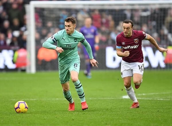 Arsenal's Aaron Ramsey Outmaneuvers West Ham's Mark Noble in Premier League Clash