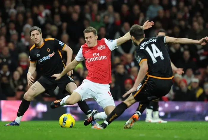 Framed Print : Arsenal's Aaron Rasmey Surges Past Wolves Stephen Ward and Roger Johnson