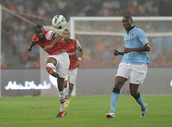 Arsenal's Abou Diaby Battles Past Yaya Toure in Arsenal FC vs Manchester City Pre-Season Clash in Beijing, 2012