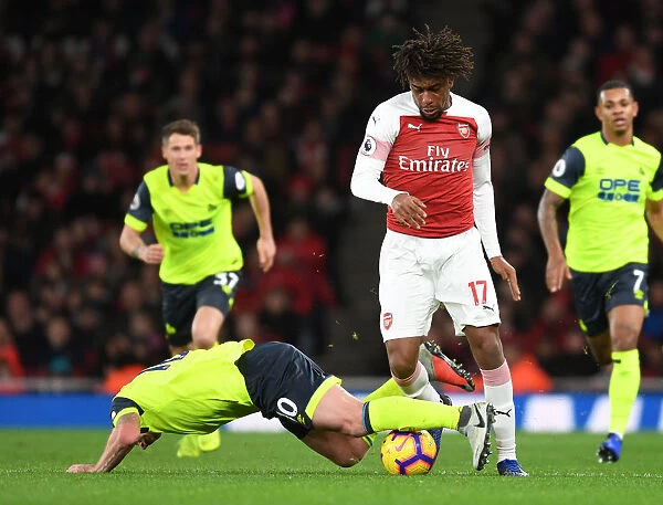 Arsenal's Alex Iwobi Faces Off Against Huddersfield's Aaron Mooy in Premier League Clash