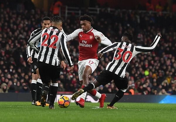 Arsenal's Alex Iwobi Faces Off Against Newcastle's DeAndre Yedlin and Christian Atsu during the Premier League Match