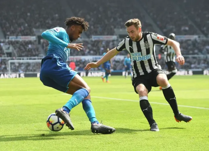 Framed Print : Arsenal's Alex Iwobi Outmaneuvers Newcastle's Paul Dummett in Intense Premier League Clash