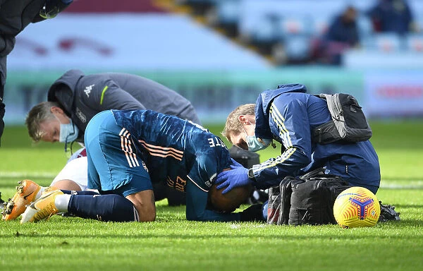 Arsenal's Alex Lacazette Receives Treatment from Physio in Empty Villa Park - Premier League 2021