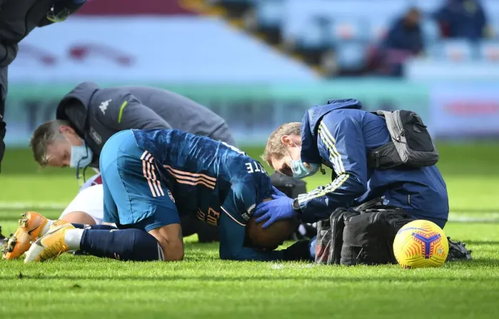 Framed Print : Arsenal's Alex Lacazette Receives Treatment from Physio in Empty Villa Park - Premier League 2021