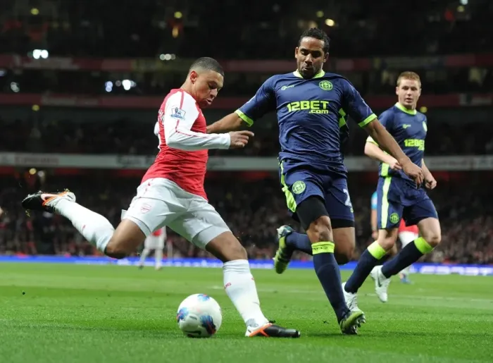 Framed Print : Arsenal's Alex Oxlade-Chamberlain Clashes with Wigan's Jean Beausejour during the Premier League Match