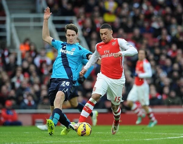 Arsenal's Alex Oxlade-Chamberlain Faces Off Against Stoke's Philipp Wollscheid in Premier League Clash