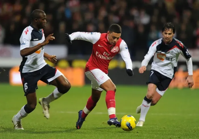 Framed Print : Arsenal's Alex Oxlade-Chamberlain Faces Off Against Bolton's Fabrice Muamba in Premier League Clash