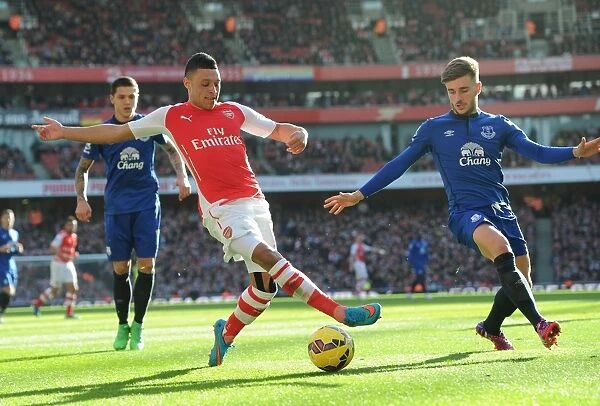 Arsenal's Alex Oxlade-Chamberlain Fends Off Everton's Luke Garbutt Challenge