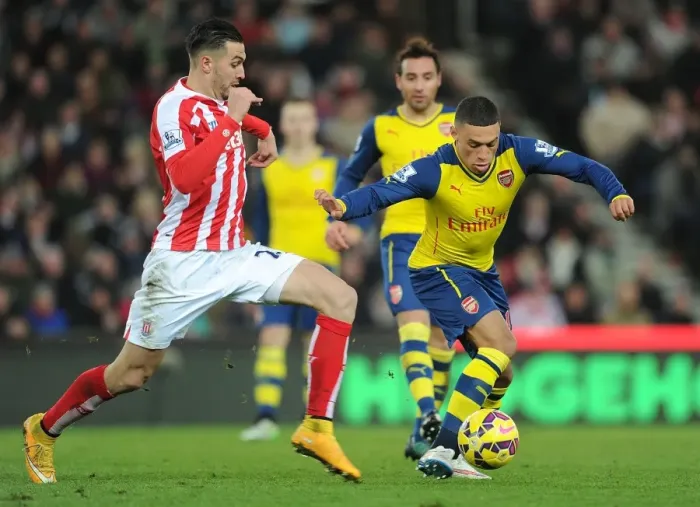 Framed Print : Arsenal's Alex Oxlade-Chamberlain Fends Off Stoke's Erik Pieters during Premier League Clash Framed Print : Arsenal's Alex Oxlade-Chamberlain Fends Off Stoke's Erik Pieters during Premier League Clash