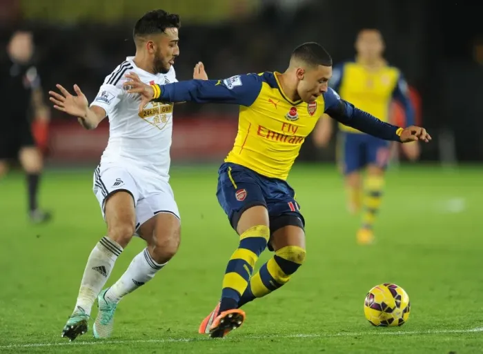 Framed Print : Arsenal's Alex Oxlade-Chamberlain Fends Off Swansea's Neil Taylor Framed Print : Arsenal's Alex Oxlade-Chamberlain Fends Off Swansea's Neil Taylor