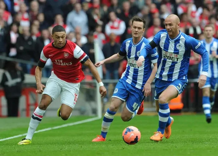 Framed Print : Arsenal's Alex Oxlade-Chamberlain Stands Off Against Wigan's Stephen Crainey and Josh McEachran in FA Cup Semi-Final Clash Framed Print : Arsenal's Alex Oxlade-Chamberlain Stands Off Against Wigan's Stephen Crainey and Josh McEachran in FA Cup Semi-Final Clash