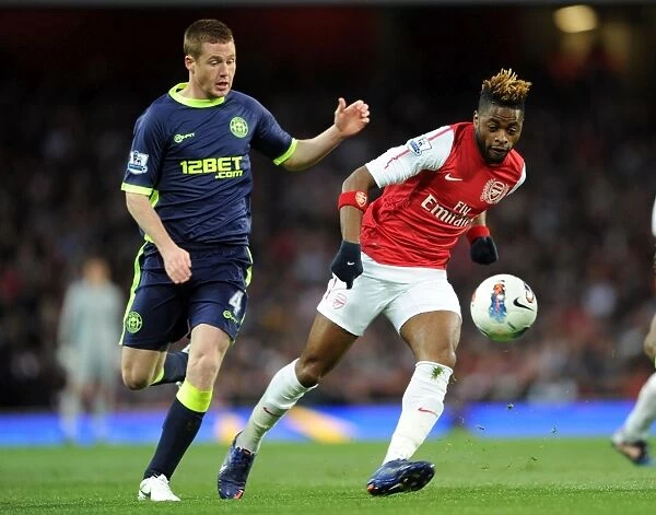 Arsenal's Alex Song Evades Wigan's James McCarthy Pressure in Premier League Clash