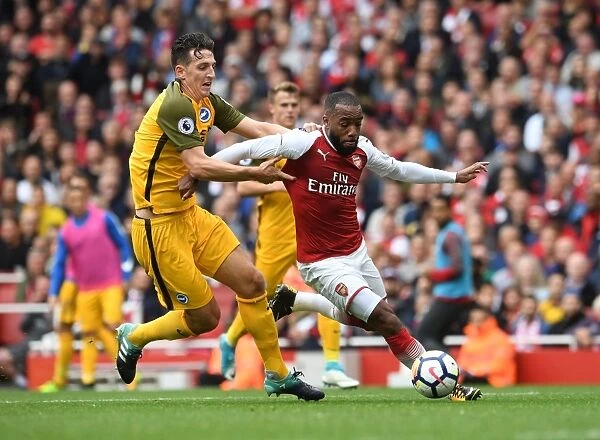 Arsenal's Alexandre Lacazette Clashes with Brighton's Lewis Dunk in Premier League Showdown