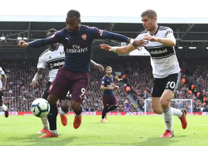 Framed Print : Arsenal's Alexandre Lacazette Clashes with Fulham's Maxime Le Marchand in Premier League Showdown