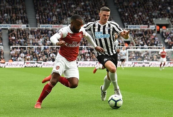 Arsenal's Alexandre Lacazette Faces Off Against Newcastle's Ciaran Clark in Premier League Clash