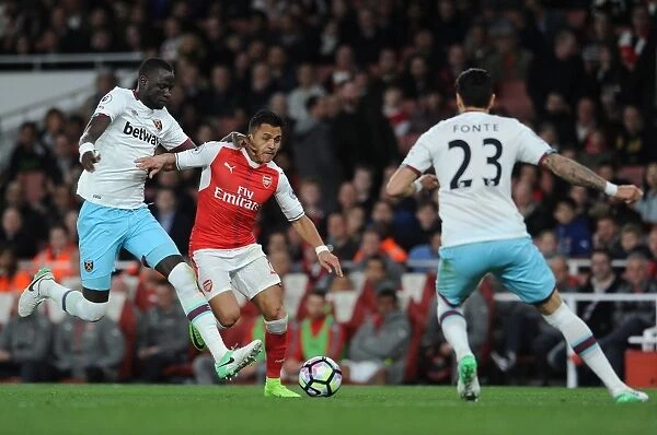 Arsenal's Alexis Sanchez Clashes with West Ham's Cheikhou Kouyate and Jose Fonte during the Premier League Match