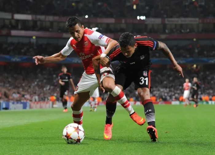 Framed Print : Arsenal's Alexis Sanchez Tackles Besiktas Ramon Motta in Champions League Showdown