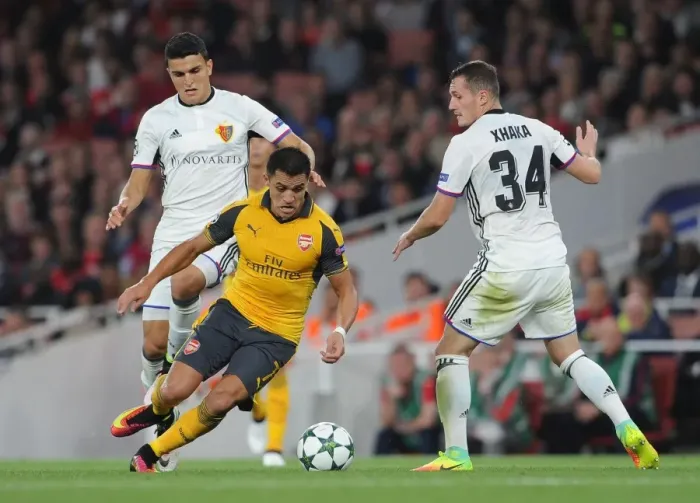 Framed Print : Arsenal's Alexis Sanchez vs. Mohamed Elyounoussi: Intense Face-Off in Arsenal vs. Basel UEFA Champions League Clash (2016-17) Framed Print : Arsenal's Alexis Sanchez vs. Mohamed Elyounoussi: Intense Face-Off in Arsenal vs. Basel UEFA Champions League Clash (2016-17)