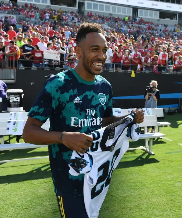 Framed Print : Arsenal's Aubameyang Receives Carolina Panthers Shirt from Christian McCaffrey Ahead of Arsenal v Fiorentina Match, 2019