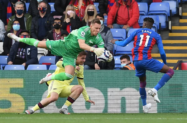 Arsenal's Bernd Leno Fends Off Pressure from Crystal Palace's Wilfred Zaha and Emile Smith Rowe