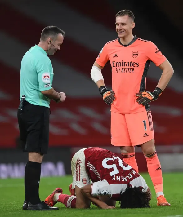 Framed Print : Arsenal's Bernd Leno Shares a Laugh with Referee Paul Tierney Amidst Mohamed Elneny Injury at Emirates Stadium
