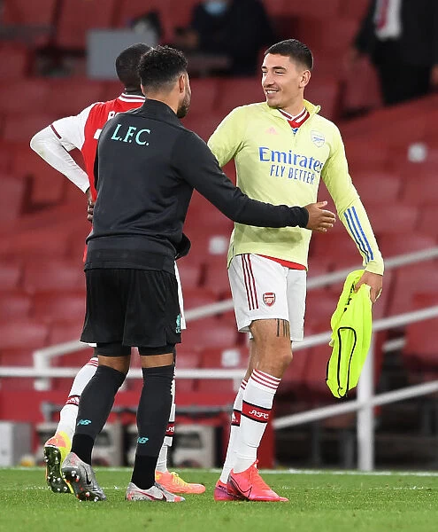 Arsenal's Bitter-Sweet Reunion: Hector Bellerin Embraces Oxlade-Chamberlain Amid Empty Emirates