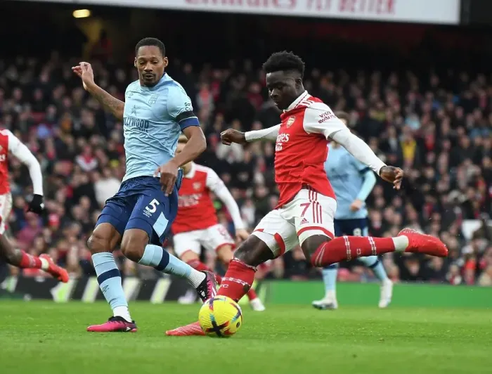 Framed Print : Arsenal's Bukayo Saka Clashes with Brentford's Ethan Pinnock in Premier League Showdown