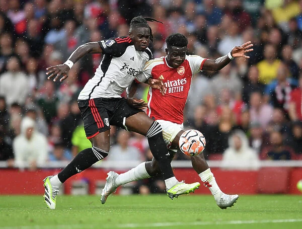 Arsenal's Bukayo Saka Clashes with Fulham's Calvin Bassey in Premier League Showdown at Emirates Stadium