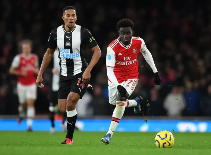 Framed Print : Arsenal's Bukayo Saka Clashes with Newcastle's Isaac Hayden in Premier League Showdown