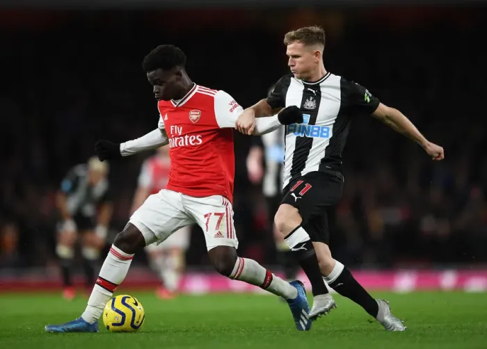 Framed Print : Arsenal's Bukayo Saka Clashes with Newcastle's Matt Ritchie in Premier League Showdown Framed Print : Arsenal's Bukayo Saka Clashes with Newcastle's Matt Ritchie in Premier League Showdown