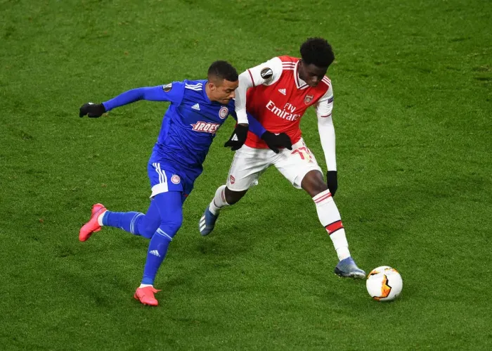 Framed Print : Arsenal's Bukayo Saka Clashes with Olympiacos Bruno Gaspar in Europa League Showdown