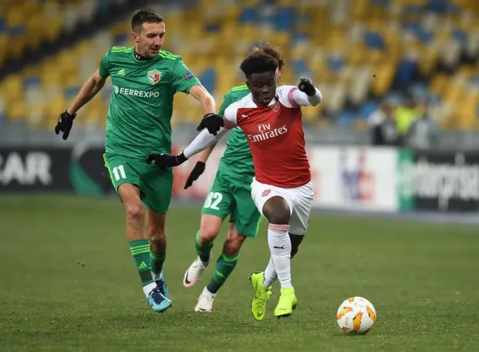 Framed Print : Arsenal's Bukayo Saka Clashes with Vyacheslav Sharpar in Europa League Showdown