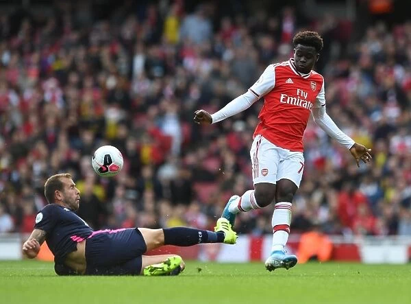 Arsenal's Bukayo Saka Faces Off Against Bournemouth's Steve Cook in Premier League Clash
