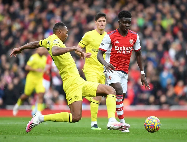 Arsenal's Bukayo Saka Faces Off Against Brentford's Ethan Pinnock in Premier League Clash