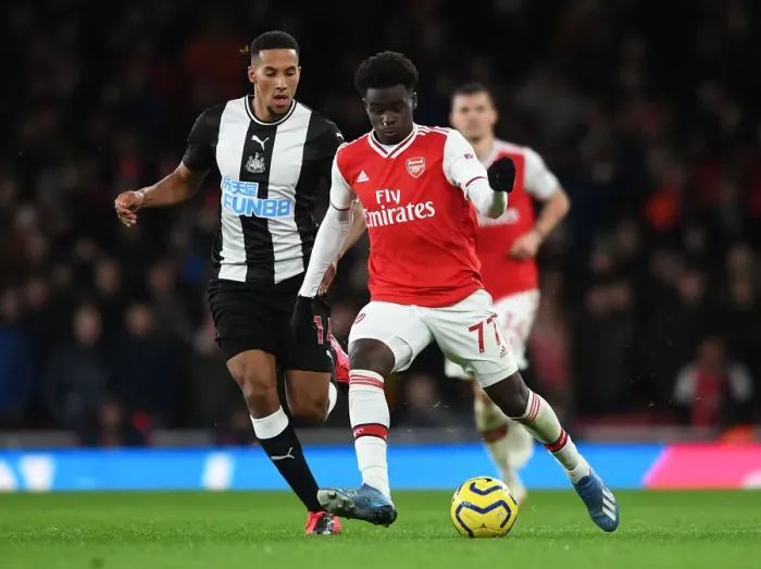 Framed Print : Arsenal's Bukayo Saka Faces Off Against Newcastle's Isaac Hayden in Premier League Clash