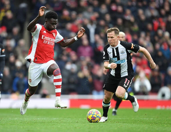 Arsenal's Bukayo Saka Faces Off Against Newcastle's Matt Ritchie in Premier League Clash