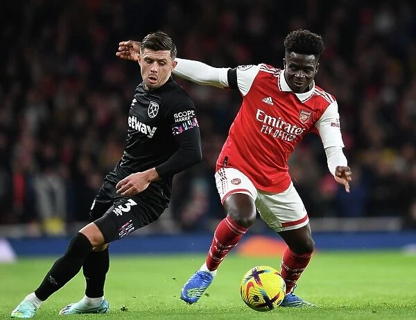 Arsenal's Bukayo Saka Faces Off Against West Ham's Aaron Cresswell in Premier League Clash