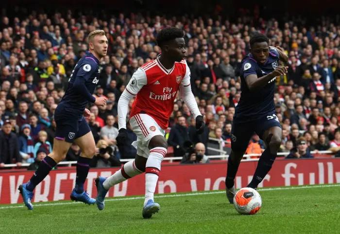 Framed Print : Arsenal's Bukayo Saka Faces Off Against West Ham's Jeremy Ngakia in Premier League Clash