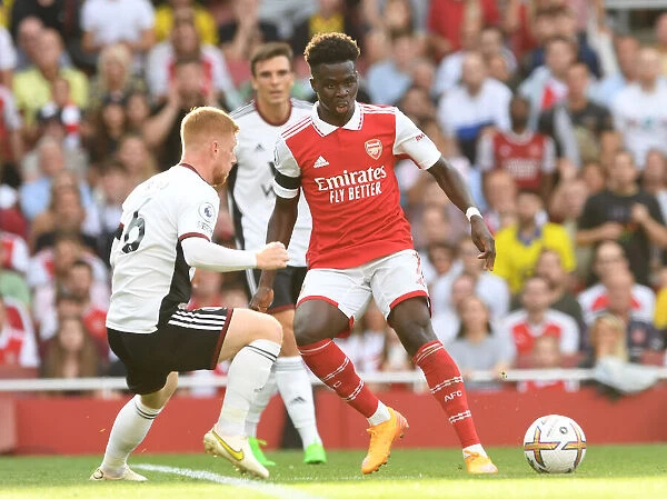 Arsenal's Bukayo Saka Fends Off Fulham's Harrison Reed in Premier League Clash