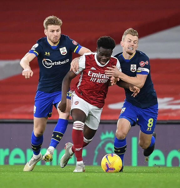 Arsenal's Bukayo Saka Goes Head-to-Head with Southampton's Stuart Armstrong and James Ward-Prowse in Intense Premier League Showdown (December 2020)