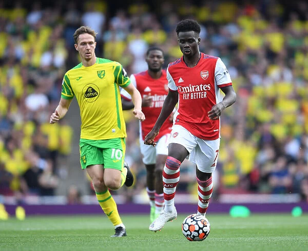 Arsenal's Bukayo Saka Outmaneuvers Norwich's Kieran Dowell in the 2021-22 Premier League Clash