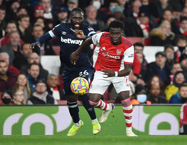 Arsenal's Bukayo Saka Outmaneuvers West Ham's Arthur Masuaku in Premier League Clash