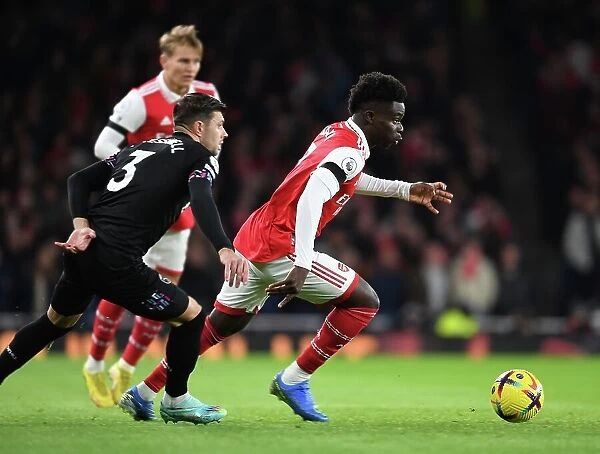 Arsenal's Bukayo Saka Outmaneuvers West Ham's Aaron Cresswell in Premier League Clash