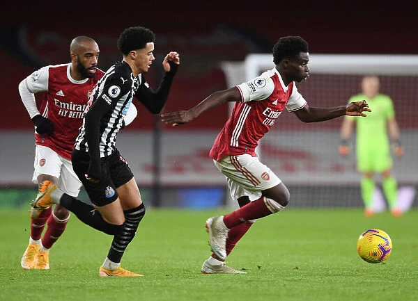 Arsenal's Bukayo Saka Outsmarts Newcastle's Jamal Lewis in Empty Emirates Stadium