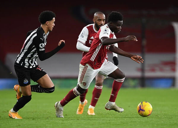 Arsenal's Bukayo Saka Outwits Newcastle's Jamal Lewis in Empty Emirates Stadium