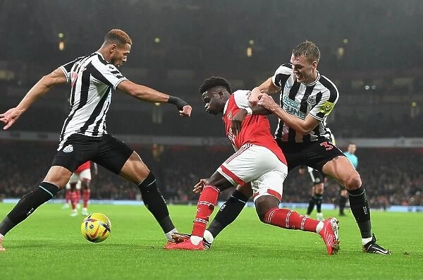 Arsenal's Bukayo Saka Overpowers Newcastle's Defense: Intense Battle against Joelinton and Dan Burn, 2023