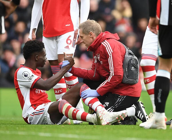 Arsenal's Bukayo Saka Receives Treatment from Physio Jordan Reece vs Newcastle United (2021-22)